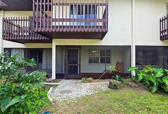 view of exterior entry featuring a balcony