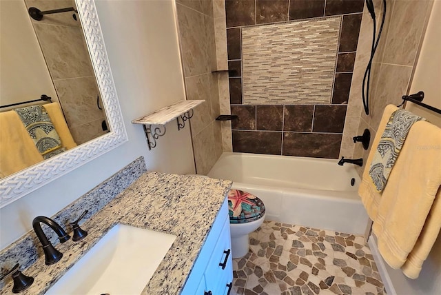 full bathroom featuring tiled shower / bath combo, vanity, and toilet