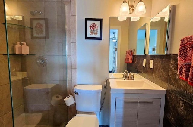 bathroom featuring vanity, backsplash, toilet, and tiled shower