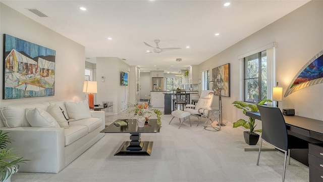 living room with a healthy amount of sunlight, light colored carpet, and ceiling fan