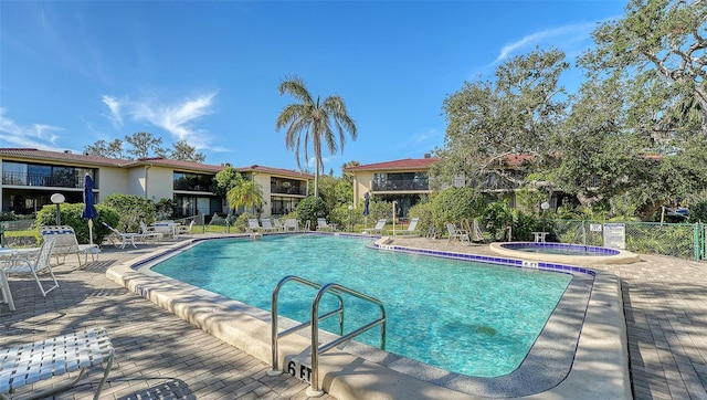 view of swimming pool with a patio area and a community hot tub