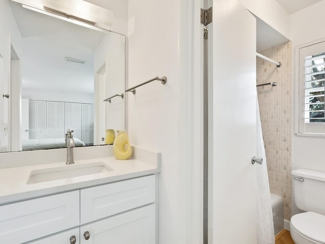 full bathroom featuring shower / tub combo with curtain, vanity, and toilet