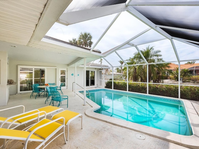 view of pool with a patio and glass enclosure