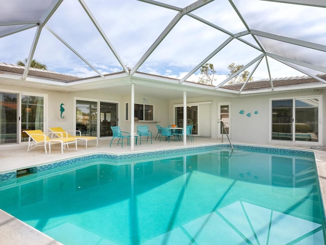 view of pool with a patio area and glass enclosure