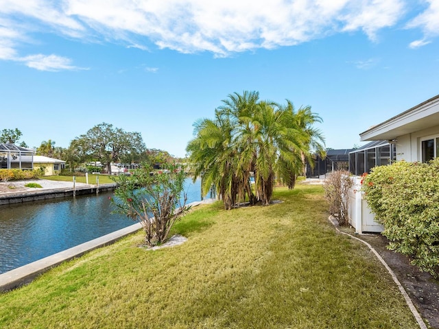 view of yard with a water view and glass enclosure