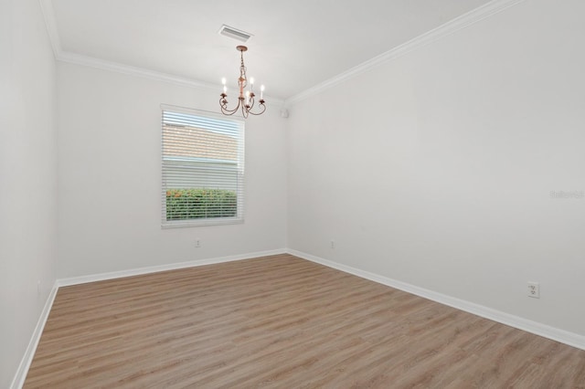 empty room with a notable chandelier, ornamental molding, and light hardwood / wood-style floors