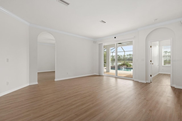 empty room featuring crown molding and hardwood / wood-style flooring