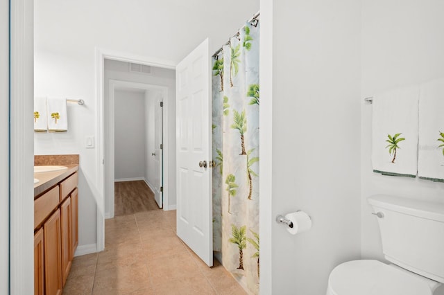 bathroom featuring curtained shower, tile patterned floors, toilet, and vanity