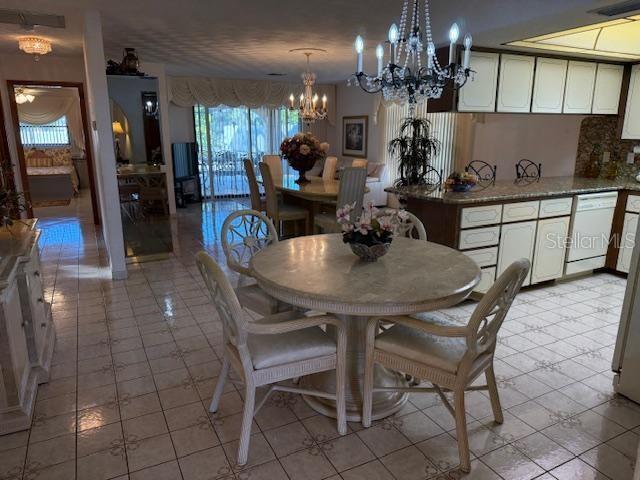 dining space featuring light tile patterned floors and a notable chandelier