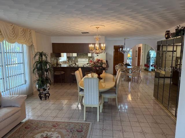 tiled dining space with a chandelier