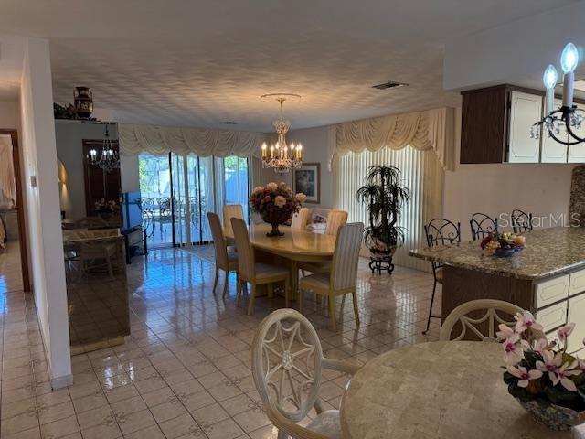 dining area featuring a notable chandelier and light tile patterned flooring