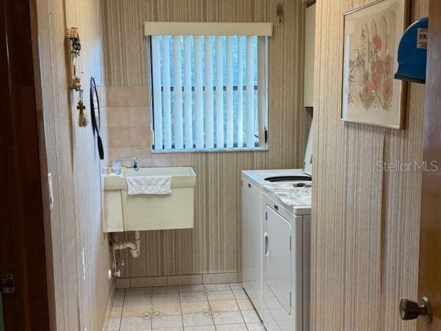 washroom featuring light tile patterned floors, washer and dryer, and sink