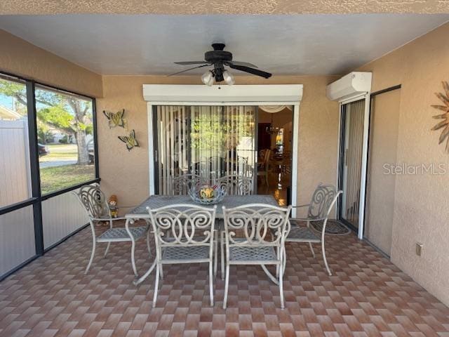 sunroom with ceiling fan and a wall mounted AC