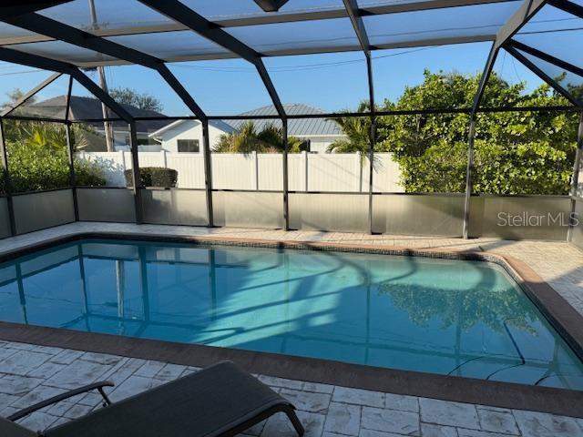 view of swimming pool with glass enclosure and a patio area