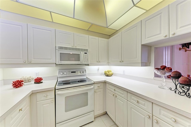 kitchen with light tile patterned floors, white cabinets, and white appliances