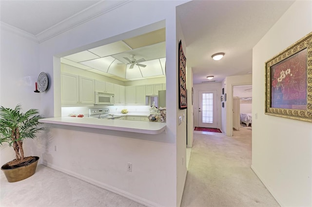 kitchen featuring light colored carpet, kitchen peninsula, ceiling fan, and range