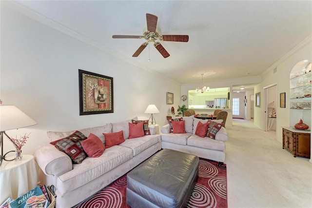 living room featuring ornamental molding, ceiling fan with notable chandelier, and light carpet