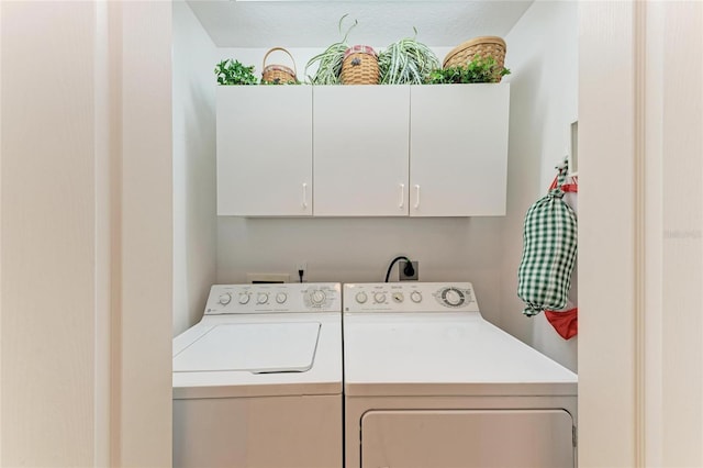 washroom with separate washer and dryer and cabinets