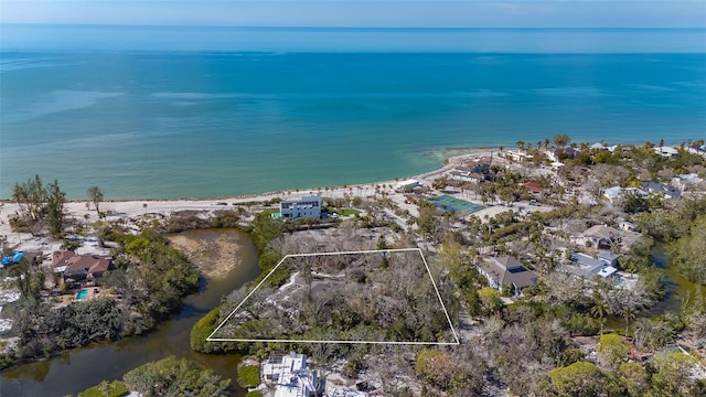 birds eye view of property with a water view and a beach view