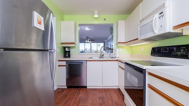 kitchen with stainless steel appliances, white cabinetry, and sink