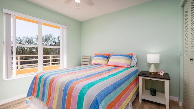 bedroom featuring hardwood / wood-style flooring, ceiling fan, and a closet