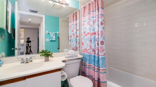 full bathroom featuring shower / bathtub combination with curtain, vanity, and toilet