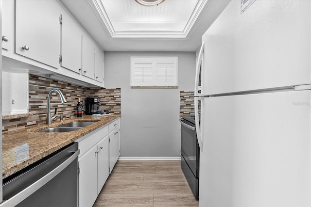 kitchen with white cabinetry, white fridge, and stainless steel dishwasher