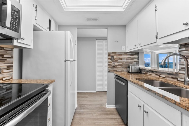 kitchen with sink, white cabinetry, stainless steel appliances, light hardwood / wood-style floors, and light stone countertops