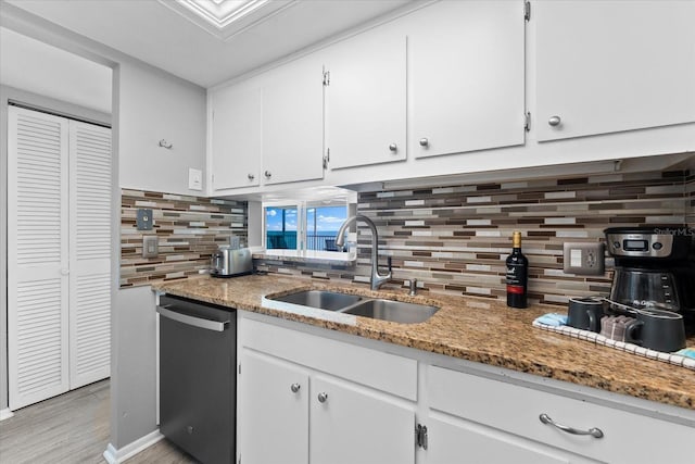 kitchen with dishwasher, sink, white cabinets, and dark stone counters