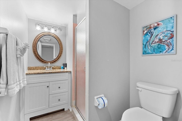 bathroom featuring vanity, hardwood / wood-style floors, toilet, and an enclosed shower