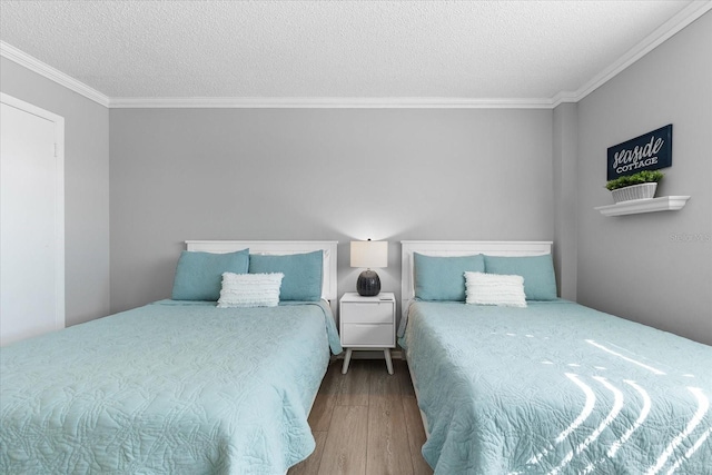 bedroom with hardwood / wood-style flooring, crown molding, and a textured ceiling