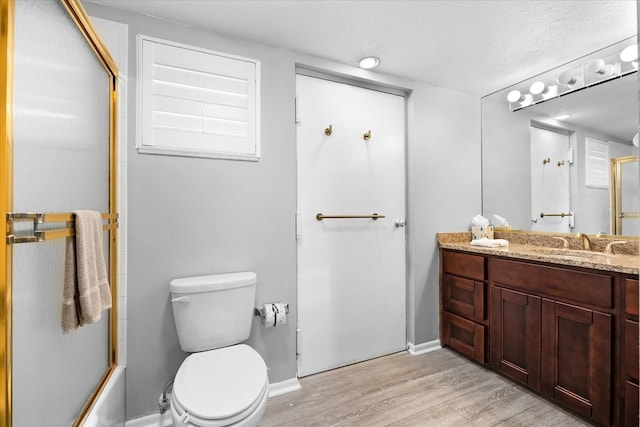 full bathroom featuring vanity, hardwood / wood-style flooring, bath / shower combo with glass door, and toilet