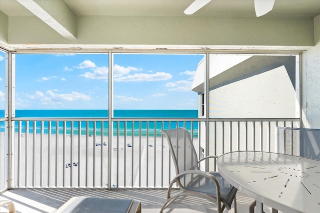 sunroom / solarium with a water view and a beach view