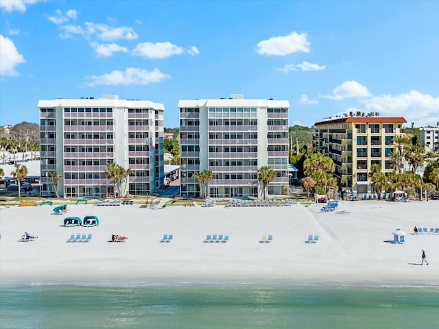 view of building exterior with a water view and a beach view