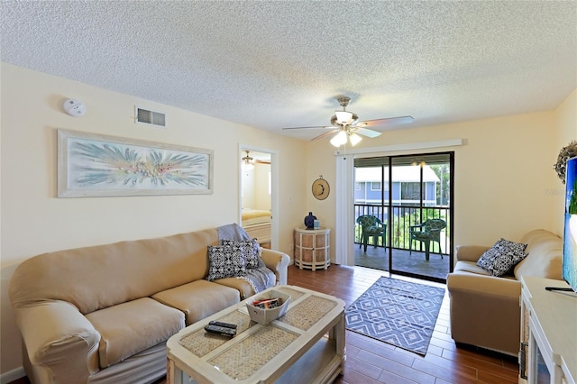 living room with ceiling fan and a textured ceiling