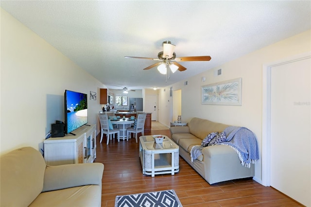 living room featuring ceiling fan and a textured ceiling