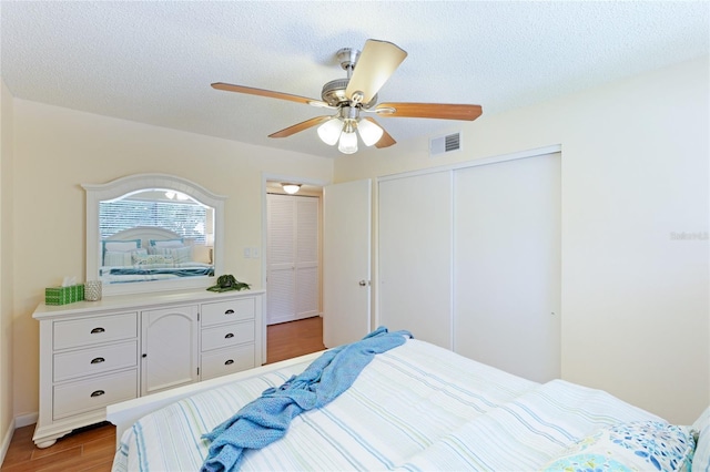 bedroom featuring a textured ceiling, ceiling fan, and light hardwood / wood-style flooring