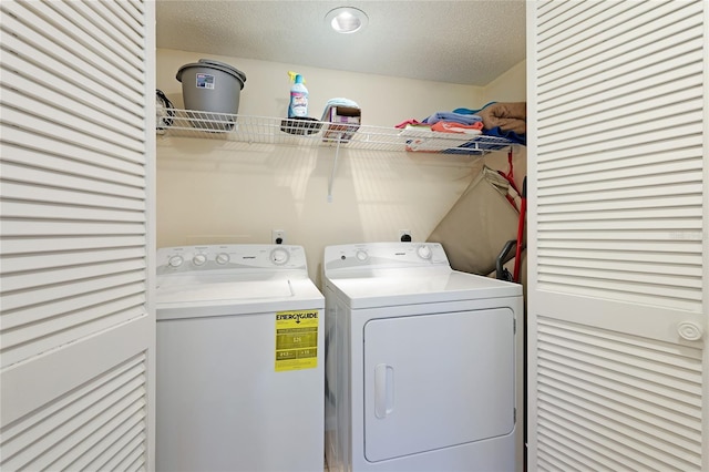 laundry room with washing machine and dryer and a textured ceiling