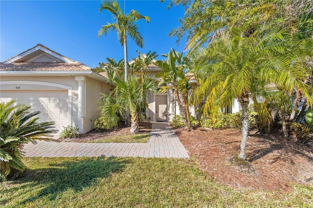 view of front of property with a garage and a front lawn