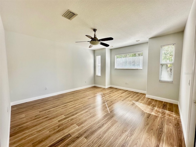 spare room featuring ceiling fan, light hardwood / wood-style floors, and a textured ceiling