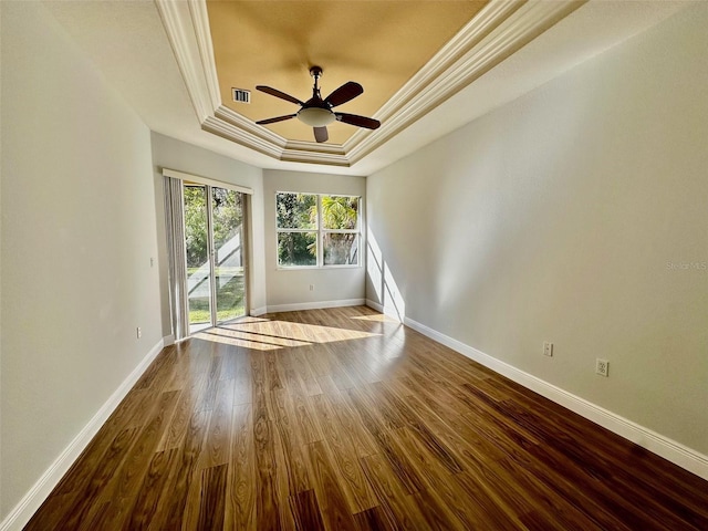 spare room featuring a tray ceiling, ornamental molding, ceiling fan, and light wood-type flooring