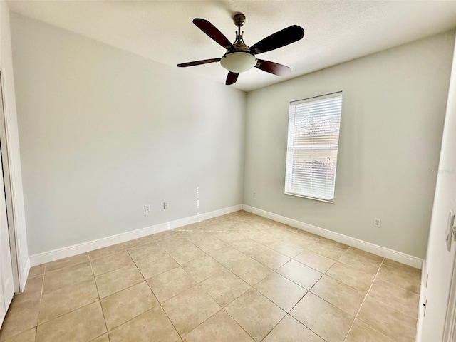 tiled spare room featuring ceiling fan