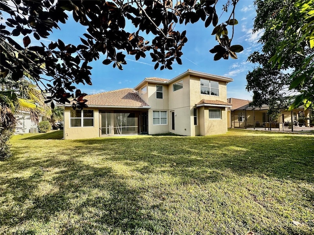 rear view of house featuring a lawn