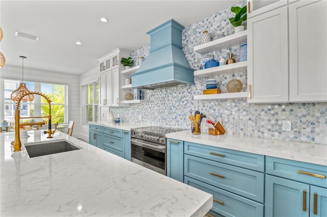 kitchen with backsplash, stainless steel electric range, decorative light fixtures, custom range hood, and light stone counters