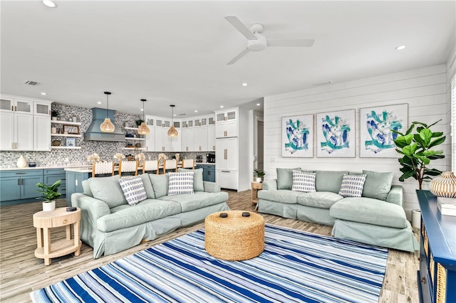 living room with ceiling fan and light hardwood / wood-style flooring