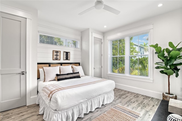 bedroom with ceiling fan, a closet, and light hardwood / wood-style flooring