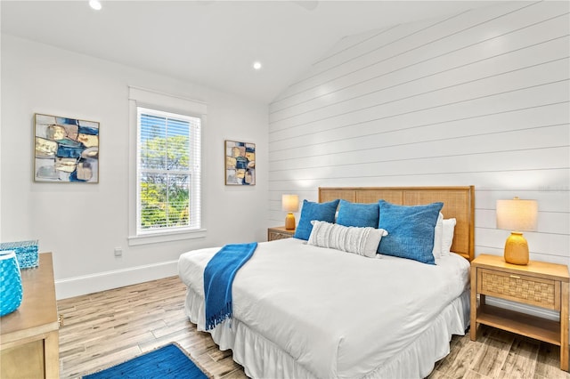 bedroom featuring lofted ceiling and light hardwood / wood-style flooring