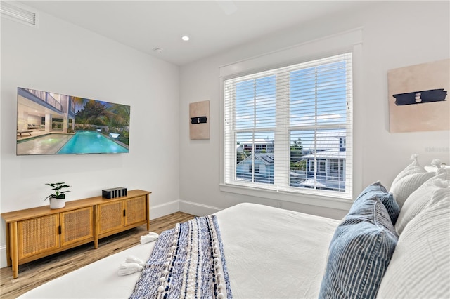 bedroom featuring multiple windows and hardwood / wood-style floors