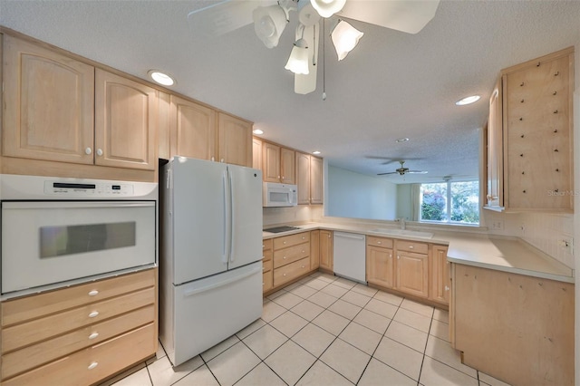 kitchen featuring light brown cabinetry, sink, white appliances, light tile patterned floors, and a textured ceiling