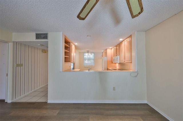 kitchen with hardwood / wood-style floors, white appliances, a textured ceiling, and light brown cabinets